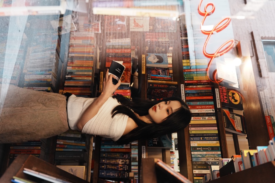 A portrait between the shelves of a bookshop